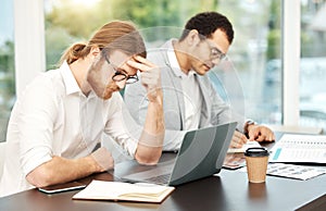 I just cant focus today. a young businessman looking stressed out while working on a laptop in an office with his