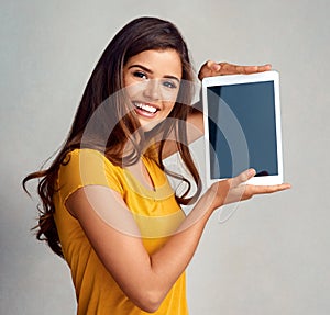 I just had to show you this. Studio portrait of an attractive young woman holding a digital tablet with a blank screen