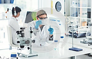 I just need a little bit of this liquid. an attractive young female scientist dropping some liquid into a beaker in a