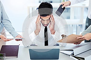 I just need a minute to myself. A young businessman looking stressed out while working in a demanding office environment