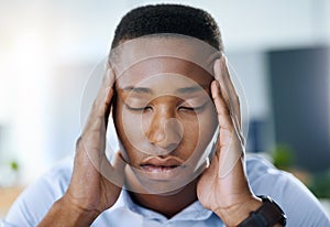 I just need to focus thats all. a young and stressed businessman suffering from a headache while trying to work in the