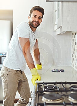 I keep my kitchen hygienically clean. Cropped portrait of a handsome young man cleaning his kitchen at home. photo