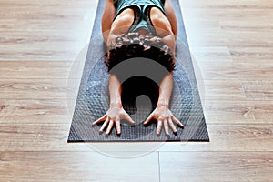 I kneel before you, yoga gods. a fit young woman practicing the childs pose during a yoga session.