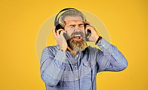 i like it so much. brutal hipster wear earphone. singing and dancing. Enjoying favorite music. Man listen music with his