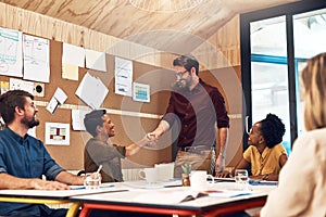 I look forward to producing some impressive work together. businesspeople shaking hands during a meeting in an office.