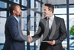 I look forward to working with you in the future. two handsome middle aged businessmen shaking hands in a modern office.