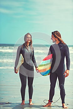 I love anybody who loves surfing. a young couple surfing at the beach.