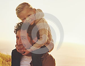 I love being daddy's girl. Shot of a father carrying his little girl on his shoulders while walking outdoors.