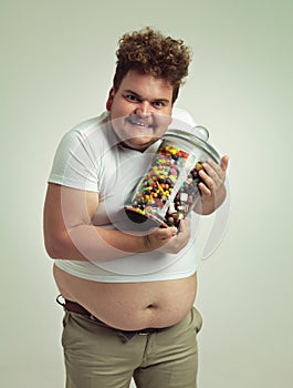 I love candy, can you tell. an overweight man holding a pot of candy.