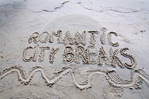 I Love City Breaks message written on sand