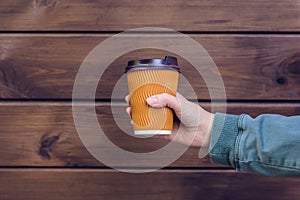 I love coffee! Person`s hand holding cup of coffee in front of brown wooden background takeaway takeaway takeout food drink beve