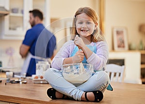 I love when dad lets me bake. a little girl stirring a bowl of batter.