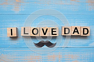 I Love DAD text and mustache on wooden background. Happy Father`s Day and International Men`s Day concepts