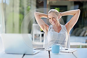 I love doing business online. a contented businesswoman leaning back with her hands behind her head.