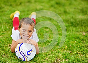 I love football. Portrait of a young boy playing soccer outside.