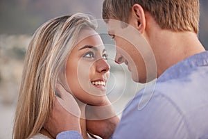 I love getting lost in your eyes. a happy young couple enjoying a romantic moment on the beach.