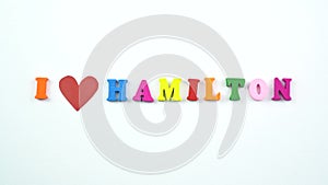 I love Hamilton. Text from colorful wooden letters and a beating paper red heart.