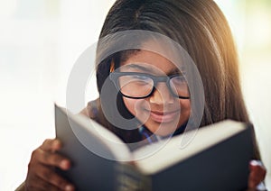 I love happy endings. a cute little girl reading a book in her bedroom.