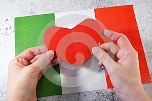 I love Italy. Hands hold red heart symbol on Italian flag background. Festa della Repubblica, 2 june, italy day