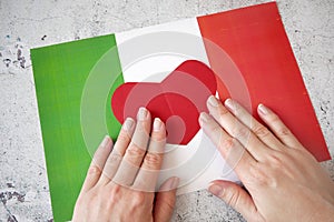 I love Italy. Hands hold red heart symbol on Italian flag background. Festa della Repubblica, 2 june, italy day