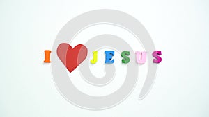 I Love Jesus text from colorful wooden letters and a beating paper red heart.