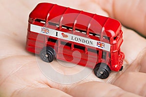 I love London message on red bus, souvenir and symbol of London City, isolated on womanâ€™s hand