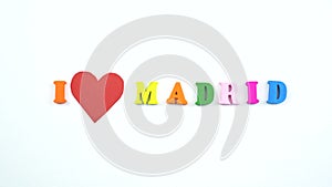 I love Madrid. Text from colorful wooden letters and a beating paper red heart.