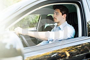 I love my car. Handsome young man driving his car and smiling at camera