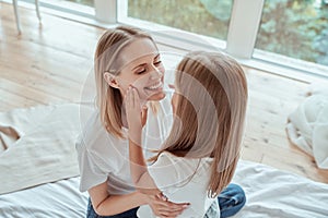 I love my mom. Happy Mothers Day. Beautiful mom with her little cute daughter are having fun at home. Doing makeup to each other