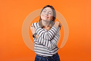 I love myself! Portrait of gentle lovely beautiful woman with brown hair in long sleeve shirt. indoor studio shot isolated on