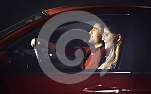 I love our drives. a young couple traveling in a car together at night.