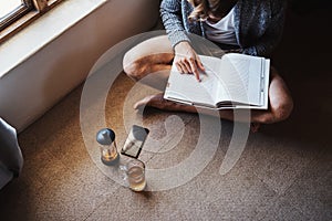 I love this part right here. High angle shot of an unrecognizable man reading a book while sitting on the floor at home.