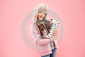 I love pets. small girl care dog toy. pet care concept. little child warm puffer jacket. fashionable kid earflap hat