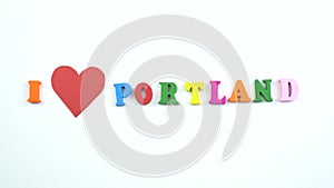 I love Portland. Text from colorful wooden letters and a beating paper red heart.