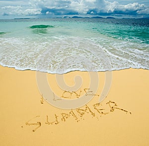 I love summer written in a sandy beach