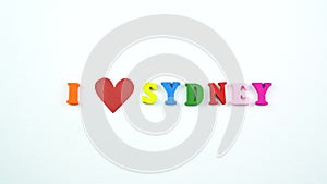 I love Sydney. Text from colorful wooden letters and a beating paper red heart.