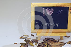 I love Tuesday written on a chalkboard. Autumn seasonal flat lay photo on White background