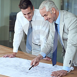 I love what youve done here. two architects looking at blueprints in an office.