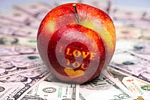 I love You apple with heart on dollar banknotes. The concept of love and prosperity. Closeup