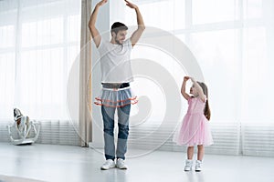 I love you, dad! Handsome young man is dancing at home with his little girl. Happy Father`s Day!