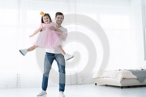 I love you, dad! Handsome young man is dancing at home with his little girl. Happy Father`s Day!
