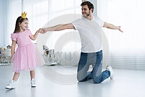 I love you, dad! Handsome young man is dancing at home with his little girl. Happy Father`s Day!