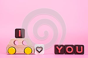 I love you engraved in chocolate and toy car on colored background