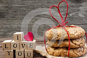 I love you inscription with wooden heart and pile of homemade cookies