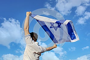 I love you Israel, concept. A young Israeli man, loving Israel, raised the flag of Israel to the sky above his head photo