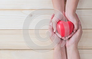 I love you Mom, Mother`s Day celebration with woman holds young kid`s hands supporting red heart gift, and charity donation