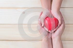 I love you Mom, Mother`s Day celebration with woman holds young kid`s hands supporting red heart gift, and charity donation