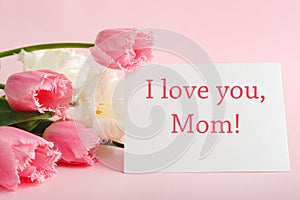 I love you Mom text on gift card in flower bouquet on pink background. Greeting card for Mom. Happy Mothers Day. Flower delivery.