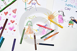 I love you, mom. Top view of beautiful colorful child drawings for mothers day and colored pencils on white background