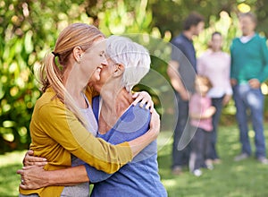 I love you, mom. a woman embracing her mother in the yard.